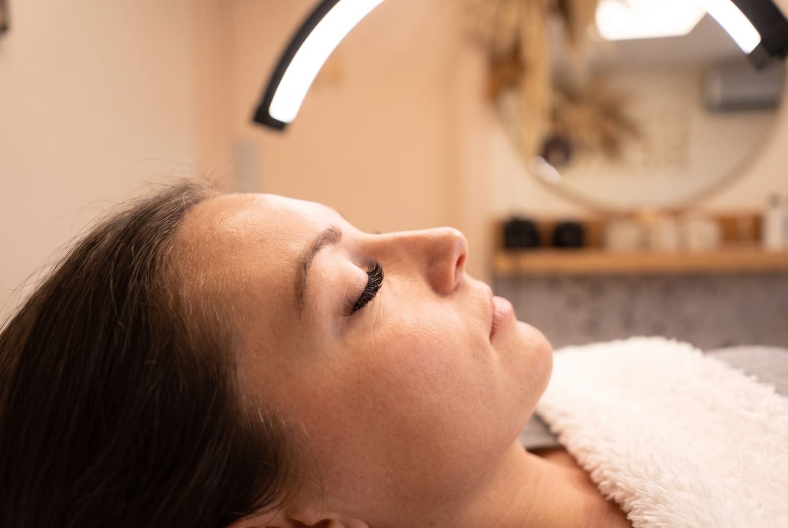 Close side profile of a full set of dark lash extensions on a client resting in the NU Beauty brow and lash treatment room in Haverhill