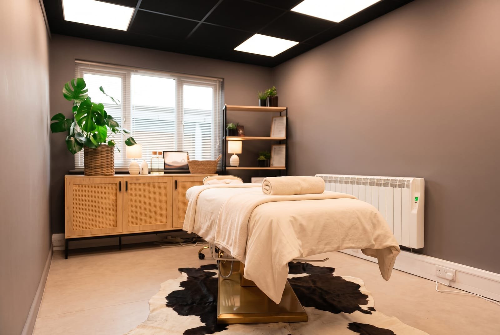 The calm massage room at NU Beauty in Haverhill, dressed with cream linen