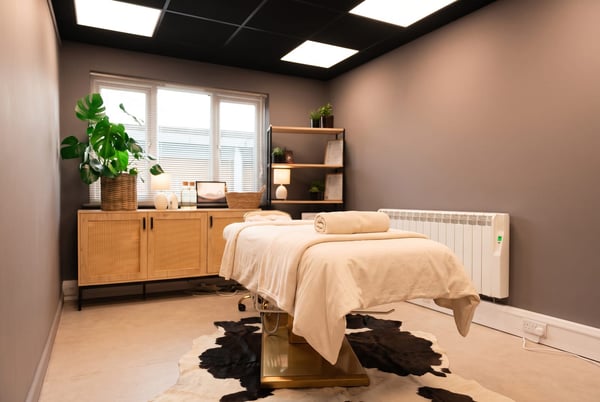 The calm massage room at NU Beauty in Haverhill, dressed with cream linen