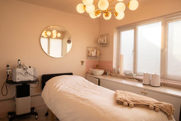 The advanced facials treatment room at NU Beauty in Haverhill, with a dressed treatment bed and a skincare machine, ready for a dermaplaning facial
