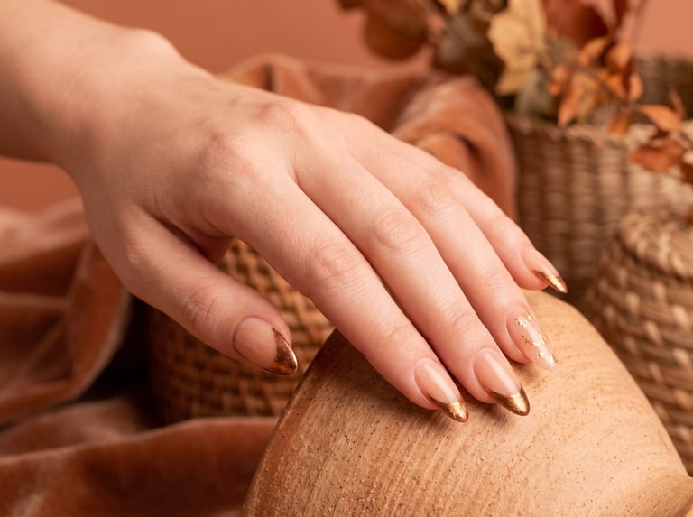 Autumn 2026 nail idea: Longer almond nails with warm copper and gold-leaf French tips over a nude base